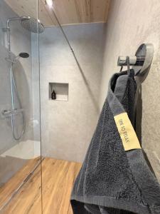 um chuveiro com uma toalha cinza pendurada em um suporte em Mallnbach Apartments em Mallnitz