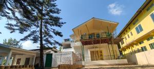 MajuliApun Majuli Guest House的前面有一棵树的建筑物