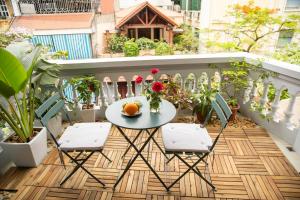 a table and chairs on a balcony with plants at Picturesque Hanoi Homestay in Hanoi