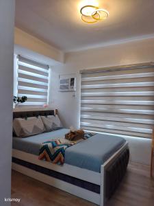 a bedroom with a bed and a window with blinds at Skyline Suite 510 at Mesavirre Garden Residences in Bacolod +9 photos
