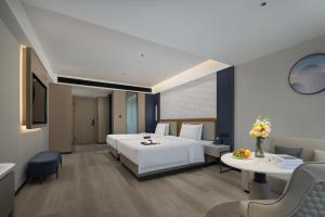 Postel nebo postele na pokoji v ubytování Huanman Hotel Luoyang Yingtianmen Jiefang Road Metro Station Branch