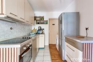 una cucina con mobili bianchi e un frigorifero di Villa Mavi a Drežnik Grad