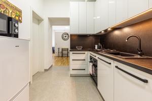una cucina con mobili bianchi e un lavandino di Compact Luxury by JR City Apartments a Größing