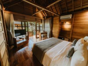乌布Harmony Wooden Villas的一间卧室，里面有一张床和一台平板电视