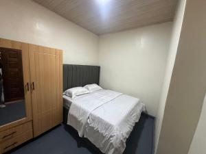 Un dormitorio pequeño con una cama y un armario de madera. en Kigali Delight Villas, en Kigali
