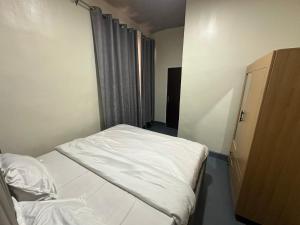 Una pequeña habitación con una cama y una ventana. en Kigali Delight Villas, en Kigali