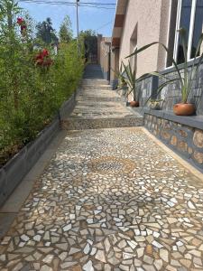 Una pasarela con rocas y plantas al lado de un edificio. en Kigali Delight Villas, en Kigali