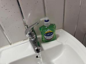 バーミンガムにあるPrime Hotelのバスルームのシンクに置かれた緑色の洗剤のボトル +3枚の写真