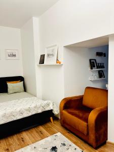 ein Schlafzimmer mit einer Couch, einem Bett und einem Stuhl in der Unterkunft GREEN Apartment in Riga