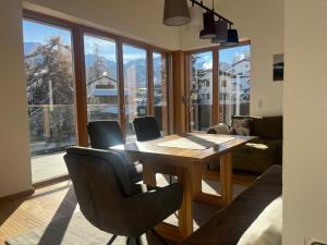 Una sala de estar con una mesa y sillas de madera. en Apart Recheler, en Ladis