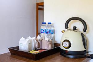 a tea kettle and bottles of water on a table at Panpurie Koh Lanta Resort - 2-Minute Walk to the Beach in Ko Lanta Yai +69 photos