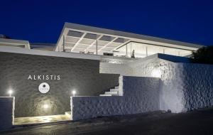 a white building with a sign on it at night at Alkistis Beach Hotel - Adults Only in Agios Stefanos