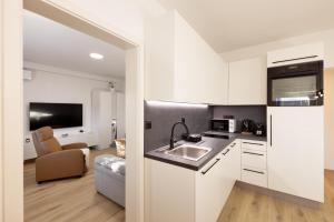 a kitchen with white cabinets and a sink at Apartments Lia in Ljubljana