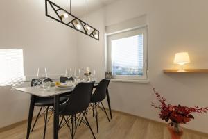 a dining room with a table and black chairs at Apartments Lia in Ljubljana +14 photos