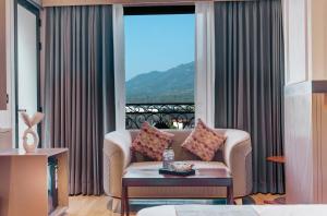 a living room with a couch and a large window at Hotel Urban chant in Rishīkesh