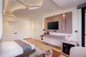 a bedroom with a bed and a flat screen tv at Hotel Urban chant in Rishīkesh +24 photos