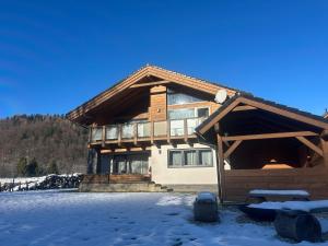 a house with snow on the ground in front of it at Chata LINDA in Mýto pod Ďumbierom