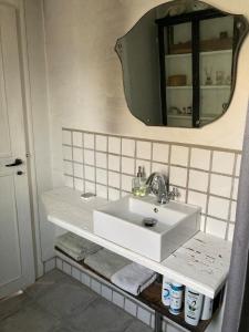 Un baño con un lavabo blanco y un espejo. en 18th century gem with soul, en Ærøskøbing