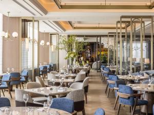 a restaurant with white tables and blue chairs at InterContinental Sapporo by IHG in Sapporo