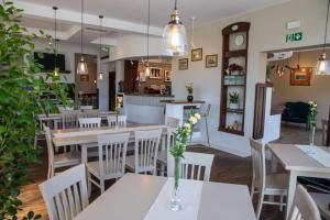 a restaurant with tables and chairs with flowers on them at Hotel Słoneczne Tarasy in Grybów