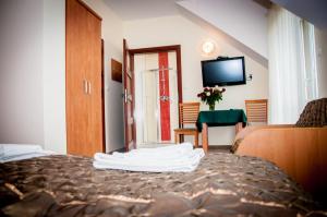 a hotel room with a bed and a television at Hotel Słoneczne Tarasy in Grybów