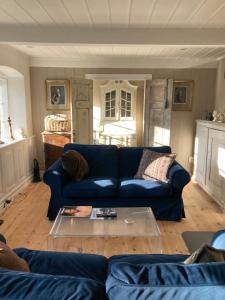 a living room with a blue couch and a table at 18th century gem with soul in Ærøskøbing