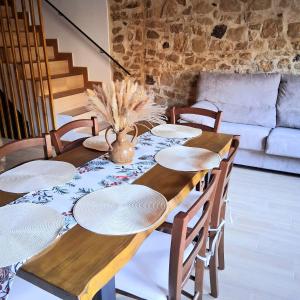 Una mesa de madera con platos blancos encima en una sala de estar. en Ca la Inés, en Corbera
