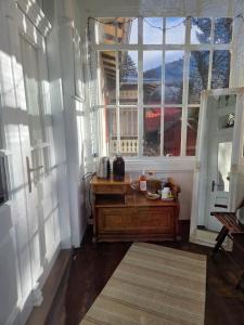 Una habitación con una mesa y una ventana grande. en Simonette Maisonette - Mountain Retreat, en Buşteni