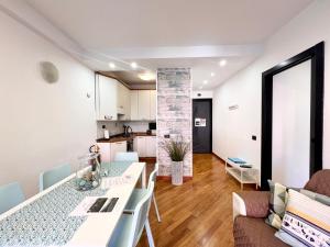 een keuken en woonkamer met een tafel en stoelen bij DOCK OF THE BAY GENOVA, Stylish Apartment in the Heart of Genoa with Air Conditioning, Private free Garage, Harbour View, extra garage at 25,00 euro per night on request, Welcome kit Priority with Prosecco in Genua