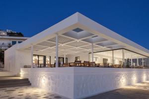 a white house with lights on it at night at Alkistis Beach Hotel - Adults Only in Agios Stefanos