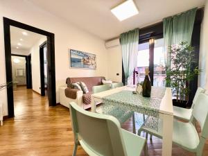 een woonkamer met een tafel en een bank bij DOCK OF THE BAY GENOVA, Stylish Apartment in the Heart of Genoa with Air Conditioning, Private free Garage, Harbour View, extra garage at 25,00 euro per night on request, Welcome kit Priority with Prosecco in Genua