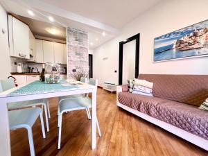 een woonkamer met een tafel en een bank bij DOCK OF THE BAY GENOVA, Stylish Apartment in the Heart of Genoa with Air Conditioning, Private free Garage, Harbour View, extra garage at 25,00 euro per night on request, Welcome kit Priority with Prosecco in Genua