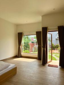 sypialnia z łóżkiem i dużym oknem w obiekcie Vy's Home Homestay Mũi Né w mieście Mui Ne