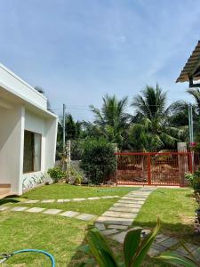 美奈Vy's Home Homestay Mũi Né的后院有红色栅栏和草坪