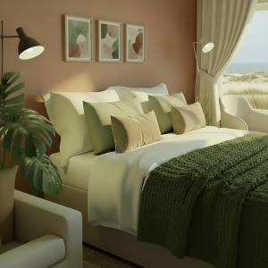 Un dormitorio con una gran cama blanca con almohadas. en Haus Meeresstern, en Wangerooge