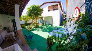 an outdoor patio with chairs and a green floor at Hostel mineiros in Aracaju