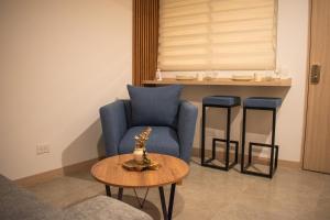 uma sala de estar com uma cadeira azul e uma mesa em Indigo 513 - Apartamento con Piscina, Gym, Parking, Ubicación 10 de 10 em Armenia