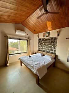 sypialnia z łóżkiem i dużym oknem w obiekcie Nirvana Bhimashankar Jungle Resort w mieście Bhimashankar