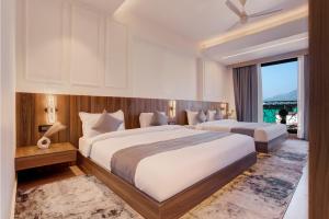 a hotel room with two beds and a window at Hotel Urban chant in Rishīkesh