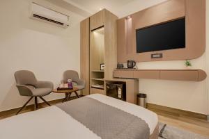 a hotel room with a bed and a flat screen tv at Hotel Urban chant in Rishīkesh