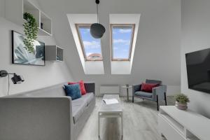 een woonkamer met een bank en een tv bij Aura III Apartments & Free Parking by Downtown Apartments in Gdańsk