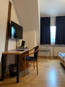 a room with a desk with a computer and a chair at Landgasthaus-Hotel Wenninghoff in Dreierwalde