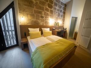 a bedroom with a large bed and a stone wall at HotelBurg Falkenberg in Falkenberg