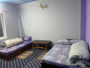 a bedroom with a bed and a small table at Aanshi homestay in Nagarkot +9 photos