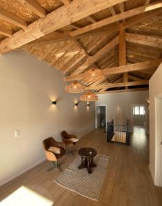 ein Wohnzimmer mit Holzdecken, Stühlen und einem Tisch in der Unterkunft Casa dos Camilos - Douro View Terrace House in Peso da Régua
