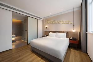 Un dormitorio con una cama blanca y un cartel en la pared. en W9-Hotel ShangHai PuDong Airport, en Shanghái 49 fotos más