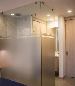 una porta doccia scorrevole in vetro in una stanza di Mostaza 316 - Lujo & Comodidad, Piscina, Gym, Parking en Av Centerario ad Armenia