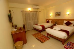 a hotel room with two beds and a television at Hotel Dream Light in Pokhara