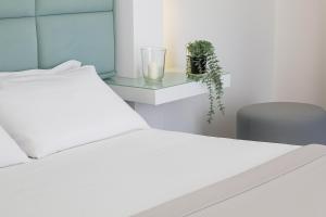 a bedroom with a white bed and a glass table at Hotiday Pozzuoli in Pozzuoli