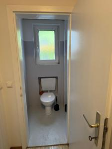 łazienka z białą toaletą w pokoju w obiekcie Danner Appartements Regau - Möblierte Langzeit- & Monteurapartments nahe Gmunden, Laakirchen, Salzburg & Wels I Vollmöbliert & mit Parkplatz w mieście Rutzenmoos +51 zdjęć